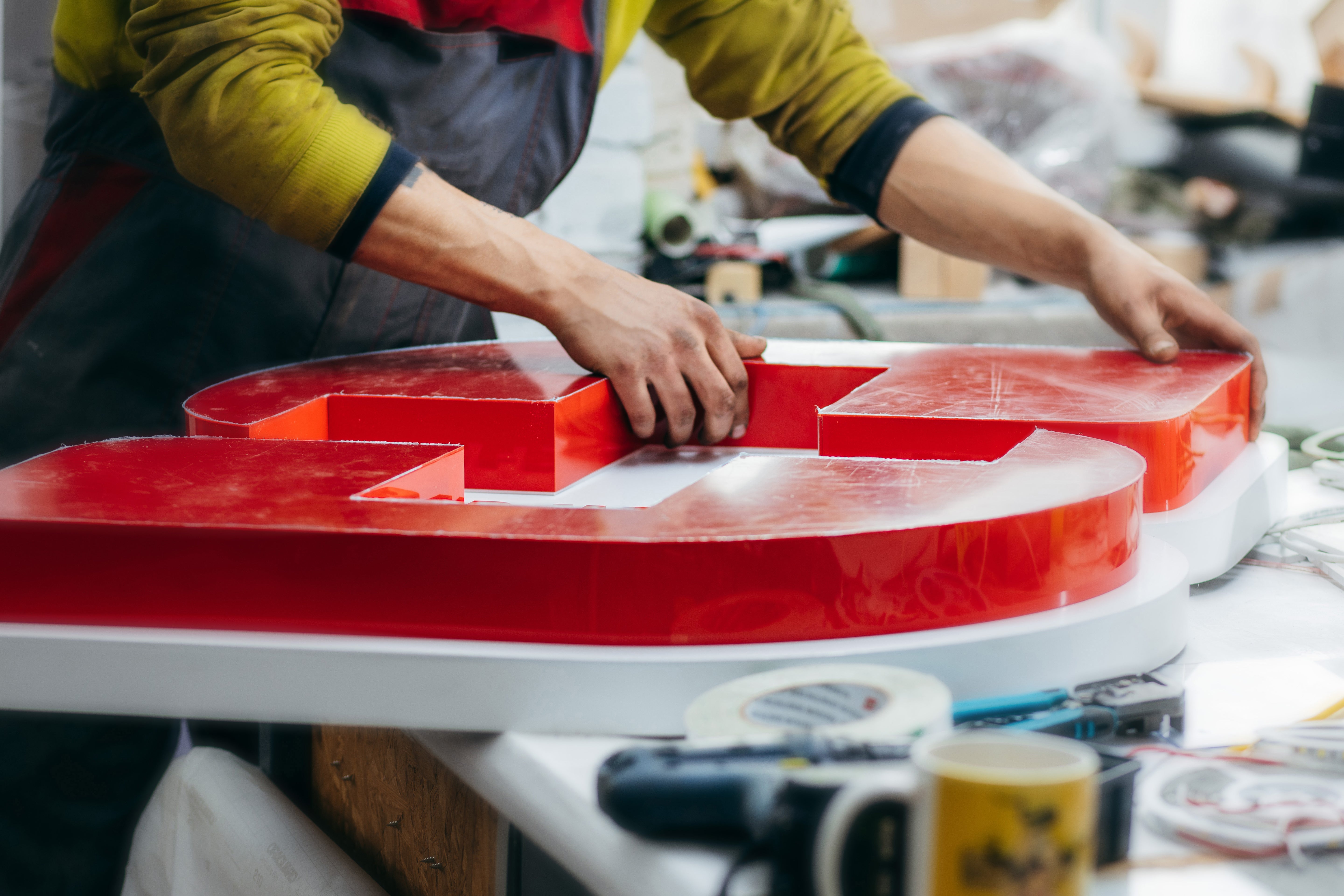 Factory worker assembling sign at private equity portfolio company